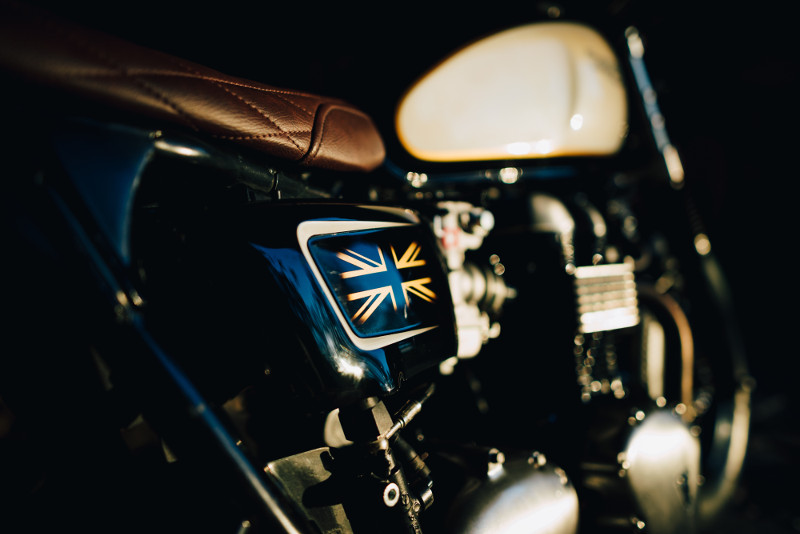 Triumph T100 Custom Bobber The modern Triumph T100 Bonneville -- aka the "New Bonneville" -- introduced in 2001, quickly earned respect in the roadster market. The (then) carbureted and air-cooled parallel twin recalled the British twins of yesteryear, with solid punch and growl, while the modern retro styling brought the Triumph brand into the new century. Said one reviewer: "I fancied trying a Sportster, but this is more fun, has heritage, and is British." Triumph T100 Custom Bobber Enter one of our favorite builders, Unik Edition Custom Motorcycles of Portugal -- a workshop we had the pleasure of visiting last year. Founded by Luís Costa and Tiago Gonçalves in 2016, the shop has gone pro, opening a new garage, bike dealership, and moto accessory shop in the Moscavide neighborhood of Lisbon. Triumph T100 Custom Bobber In the case of this build, the customer knew exactly what he wanted and eventually became part of the creative team: "We were always very aligned with the customer, with good taste, who in the end wanted a unik bike, with better performance but maintaining the elegance of the Triumph Bonneville." The result has been dubbed "Hard Brexit" -- a 2006 Triumph Bonneville "European bobber" that strikes a perfect balance between heritage, modernity, and "unik-ness." Below, we get the full story on the build. "Hard Brexit" Triumph Bonneville: Builder Interview Triumph T100 Custom Bobber • What’s the make, model, and year of the bike? Triumph Bonneville 2006. Triumph T100 Custom Bobber • Why was this bike built? Customer Project. Triumph T100 Custom Bobber • What was the design concept and what influenced the build? There are two types of clients, those who have no idea what they want, give some clues and leave and give full creative edge; and others who know perfectly what they want, eventually becoming part of the creative team. Triumph T100 Custom Bobber This customer knew perfectly what he wanted and had already bought some parts on the date of the beginning. It was a different build than we are used to, but it went very well. We were always very aligned with the customer, with good taste, who in the end wanted a unik bike, with better performance but maintaining the elegance of the Triumph Bonneville. Triumph T100 Custom Bobber • What custom work was done to the bike? CR carbs Adapted British Customs exhaust Ohlins suspension Custom wheels with firestone 500-16" tires All new electronic system, with m-unit central unit and motone buttons Complete front beringer brakes system Custom paint Custom seat Custom Bi-xenon headlight Wider front Custom aluminium fenders and brackets • Does the bike have a nickname? “Hard Brexit.” • How would you classify this bike? European Bobber. Triumph T100 Custom Bobber Follow the Builder www.unikedition.pt facebook/unikedition2016 Instagram/unikedition2016 Credits to photographer Nelson Oliveira of @no.photo.on.two.wheels